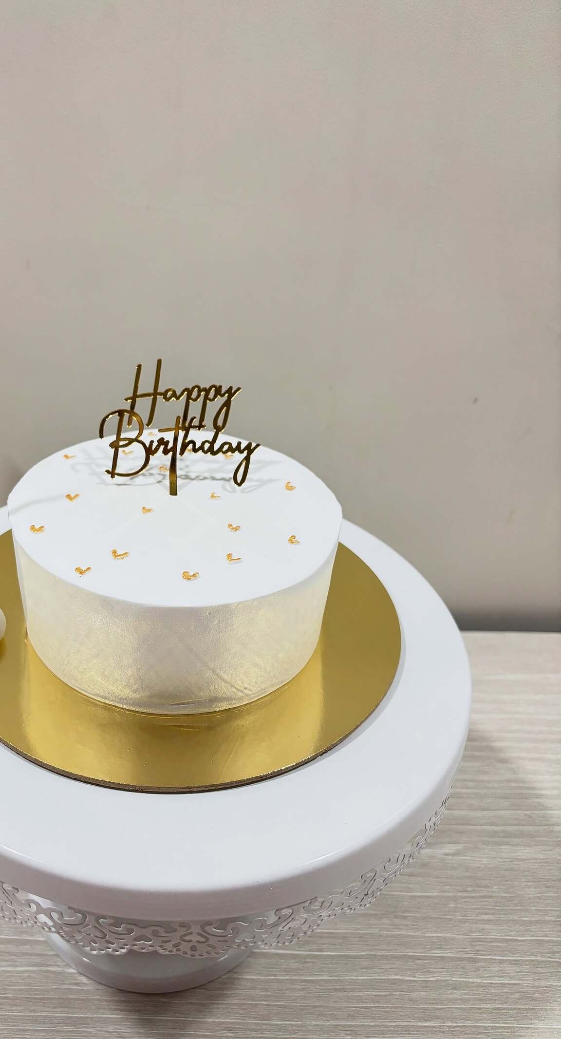 Minimal white birthday cake with gold topper
