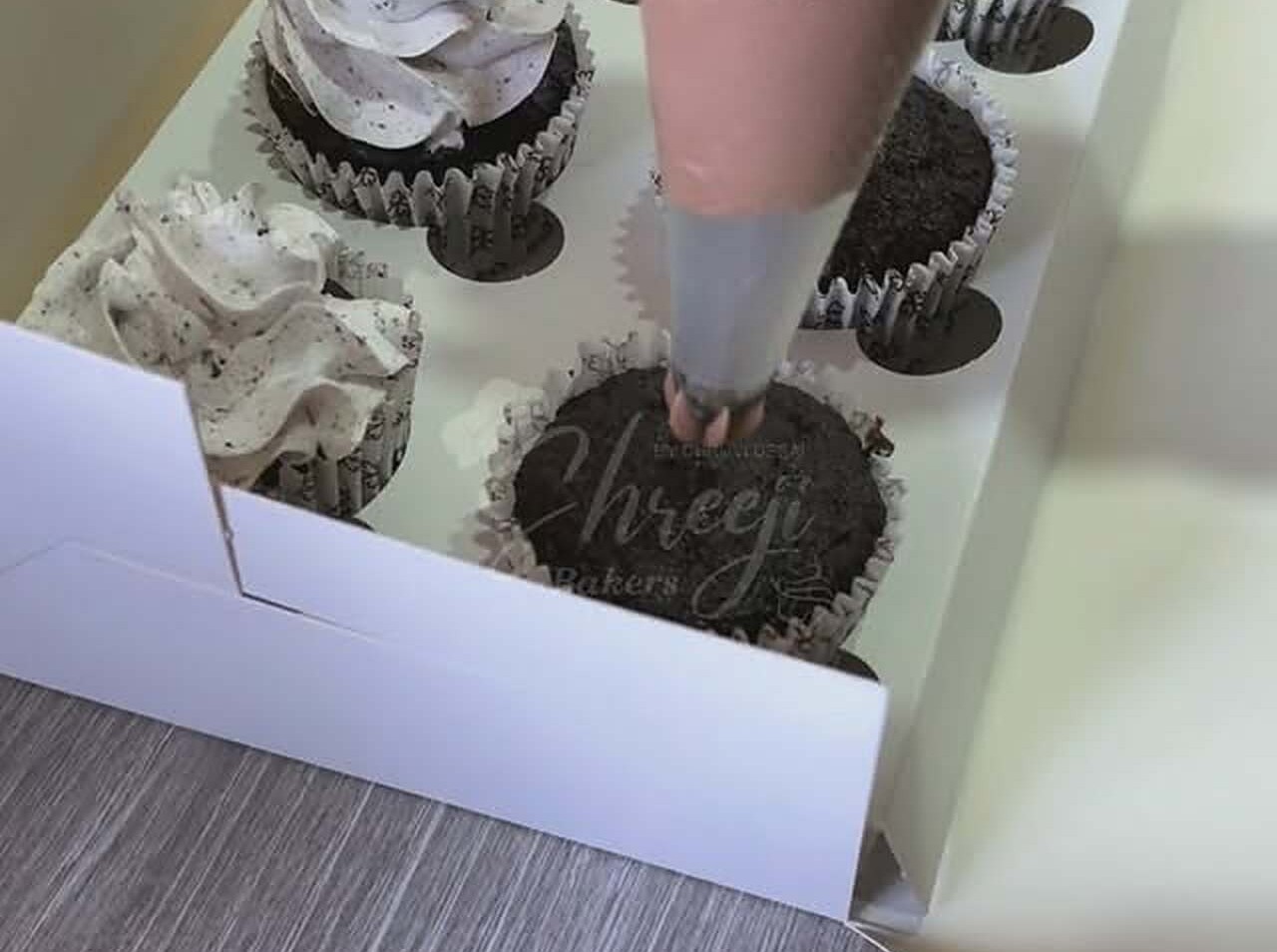 Cupcakes being frosted by hand