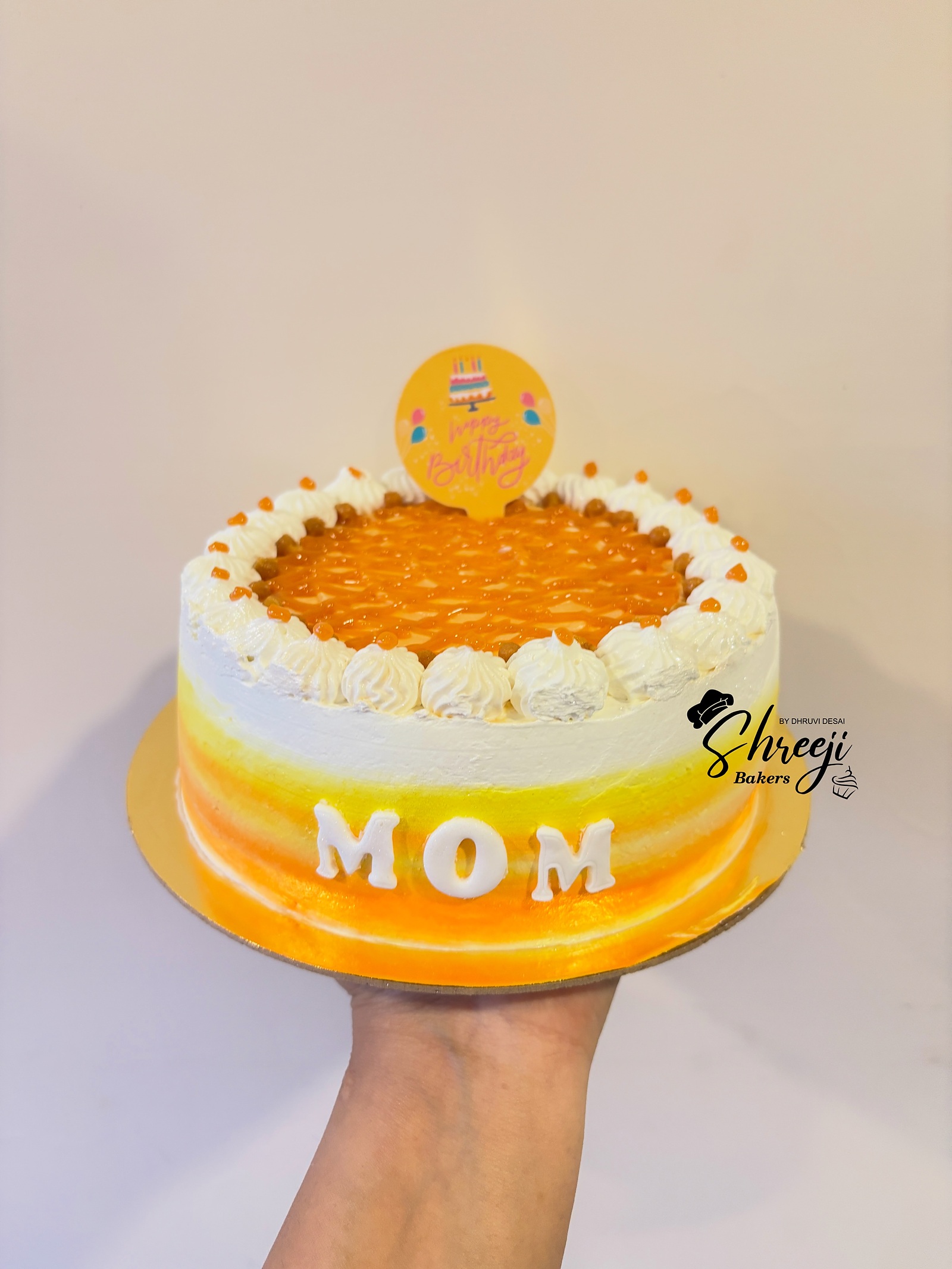 Orange celebration cake held in hand